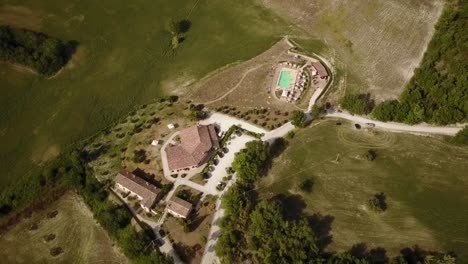 View-of-a-house-with-swimming-pool-flown-over-by-a-drone,-Italian-countryside