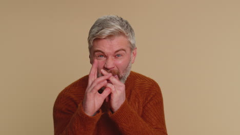 funny joyful man making playful silly facial expressions, grimacing, fooling around showing tongue