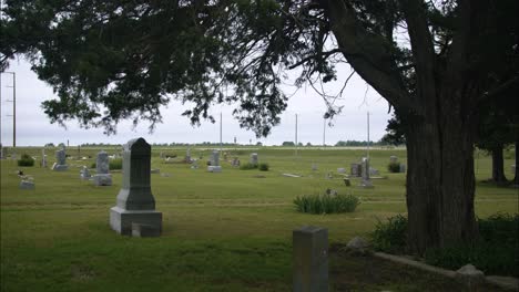 Graveyard-tombstones-and-graves-in-cemetery-on-gloomy,-cloudy-day