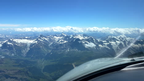 view from airplane cockpit to breathtaking mountain scenery of the alps