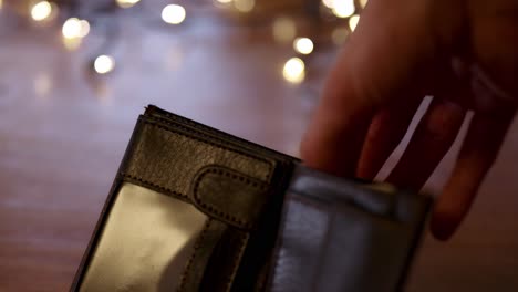 putting polish cash in and out of the wallet, christmas lights in the background, buying gifts