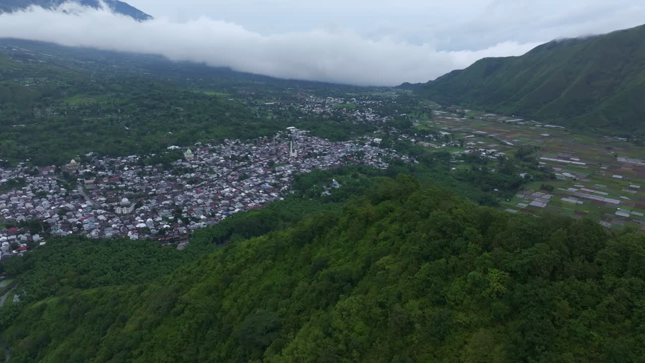 Aldeia abaixo de montanha enevoada e terras agrícolas, Sembalun, Lombok, Indonésia