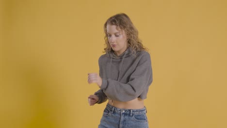 foto de estudio de una joven que se divierte bailando contra un fondo amarillo 1
