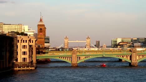 Static-wide-shot-of-boat-crossing-underneath-London-Brigde-on-Thames-River