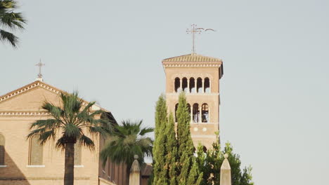 beautiful classic church in summer with trees and a flying bird in the foreground