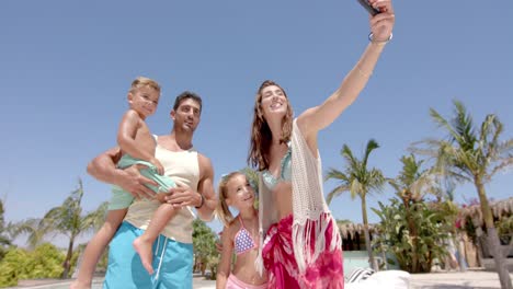 happy caucasian family taking selfie with smartphone at beach house