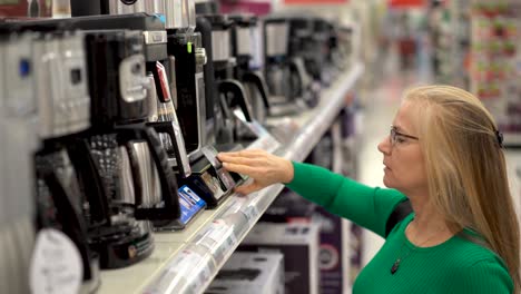 Nahaufnahme-Einer-Hübschen-Blonden-Frau,-Die-In-Einem-Laden-Auf-Kaffeemaschinen-Schaut