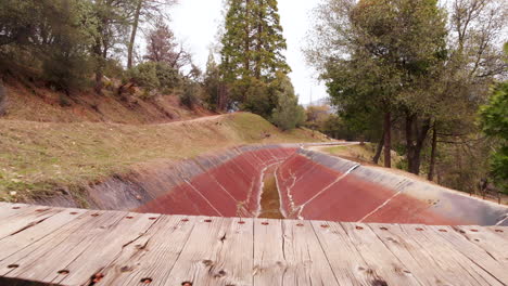 Aéreo,-Un-Dron-Vuela-Más-Allá-De-Una-Mujer-Rubia-Caminando-Sobre-Un-Puente-En-El-Bosque