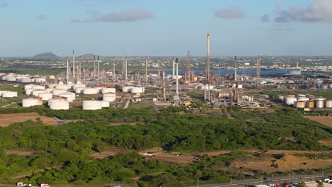 drone trucking pan of tanks and smoke stack tower spires of oil refinery in curacao