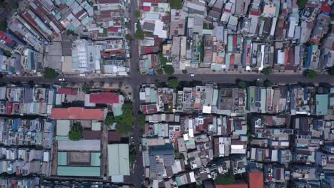 ho chi minh city, vietnam, top down aerial tracking view on a sunny day featuring the canal, rooftops of densely populated crowded residential area with road traffic