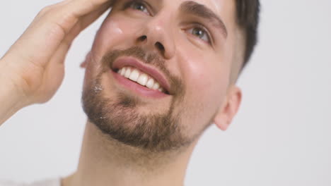 Good-Looking-Green-Eyed-Man-Applying-Moisturizer-To-His-Face