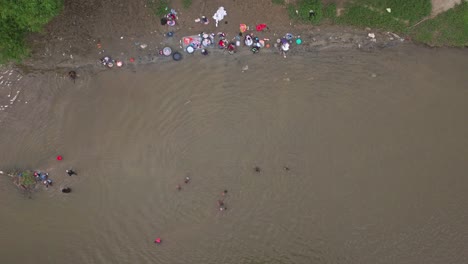 top view of haitian women washing clothes in massacre river in dajabon, dominican republic border with haiti