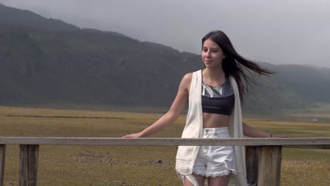frontal view of woman gazing into distance, fixing hair as it blows in wind, ecuador