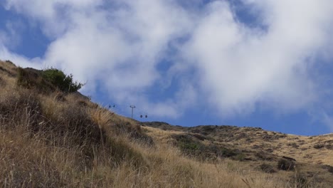 gondola cars appear tiny as clouds rush past - heathcote valley, christchurch