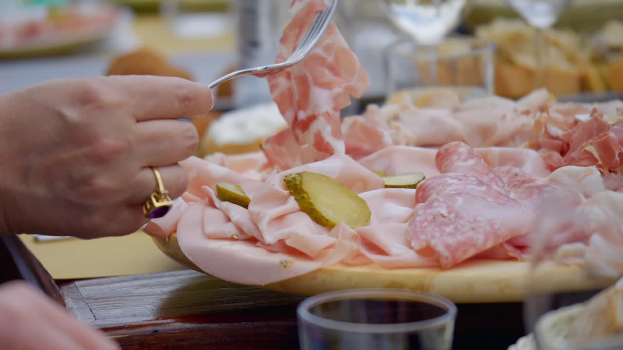 Close up Of Woman Hand Wearing Gold Ring Choosing Food From Fresh Cold Cuts Plate
