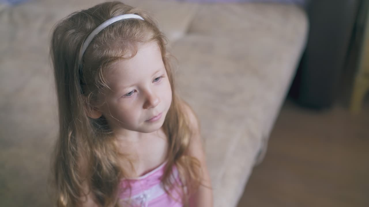 woman sprays throat of little girl using remedy on bed