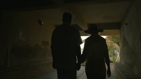 couple walking out yard of seaside hotel or house