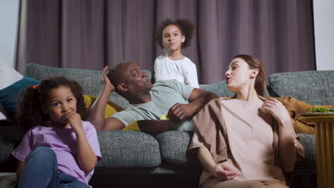 niños con padres viendo películas en casa