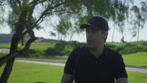 primer plano de un golfista caminando por un campo de golf hacia la cámara