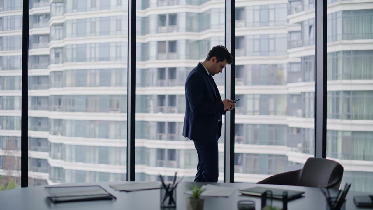 Thoughtful entrepreneur pondering business ideas standing office with smartphone