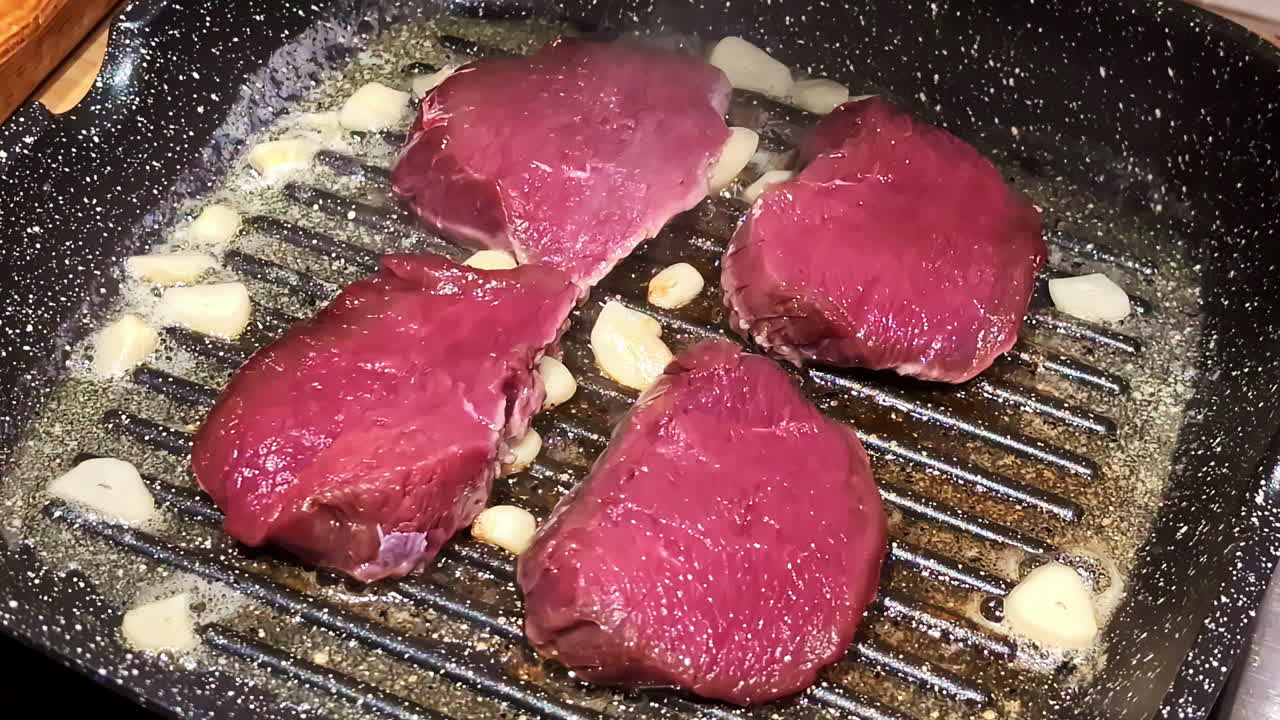 Beef meat steak cooking with garlic seasoning cast iron pan high temperature sizzling