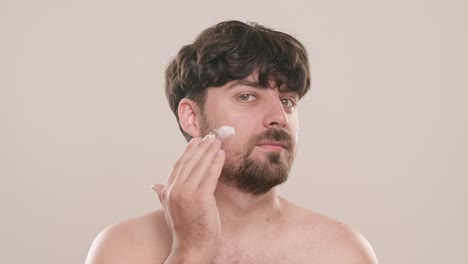 hombre aplicando crema facial