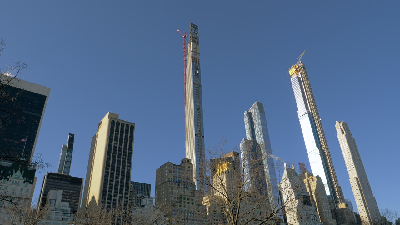 Grattacieli in costruzione con gru nello skyline di una città moderna, edifici a più piani, edifici incompiuti, sviluppo urbano, cielo azzurro limpido, crescita immobiliare, trasformazione urbana, vita urbana moderna