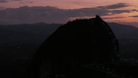 right pan drone shot el penon rock guatape colombia dark explosive sky