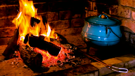 cocina sudafricana tradicional en olla de hierro fundido azul - fuego caliente