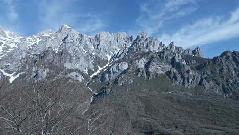 Mountain-ridge-with-trees-under-cloudy-sky