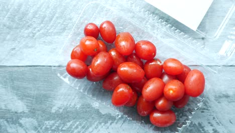 pequeño tomate rojo en un recipiente de plástico,