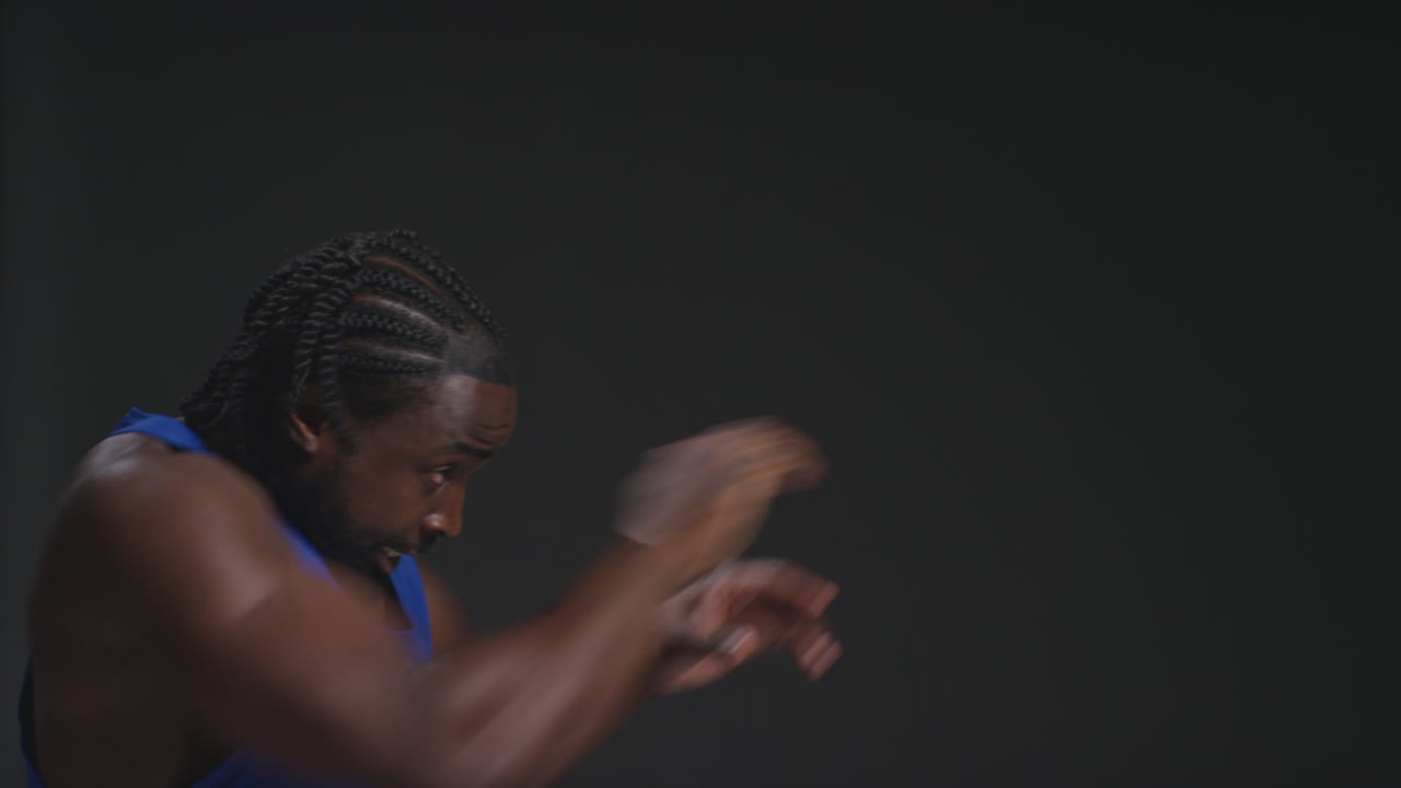 Close Up Profile Shot Of Male Boxer Training In Gym Sparring Preparing For Fight Against Black Studio Background