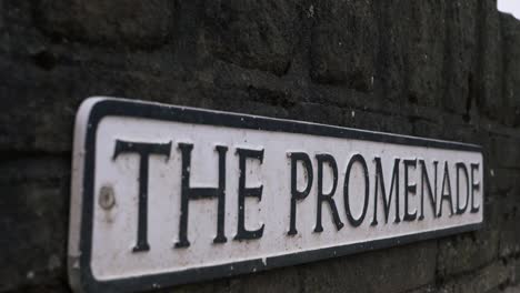 promenade street sign on a wall close up panning shot