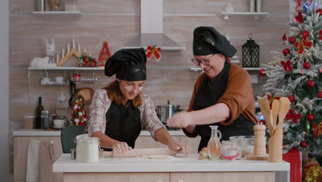 grandparent enjoying winter holidays while grandchild with apron preparing homemade cookies