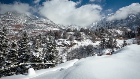 Lapso-De-Tiempo,-Idílico-Paisaje-De-Invierno-Blanco-En-Las-Montañas-En-Un-Día-Soleado,-Nubes-Y-Colinas-Y-Picos-Nevados