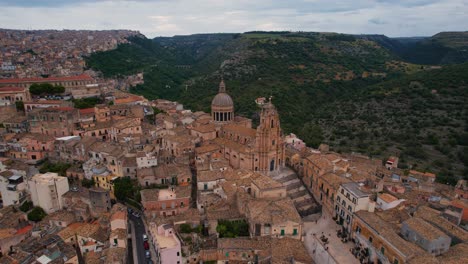 aerial drone above central piazza in ragusa with historic houses and church towers. sicily, italy.
