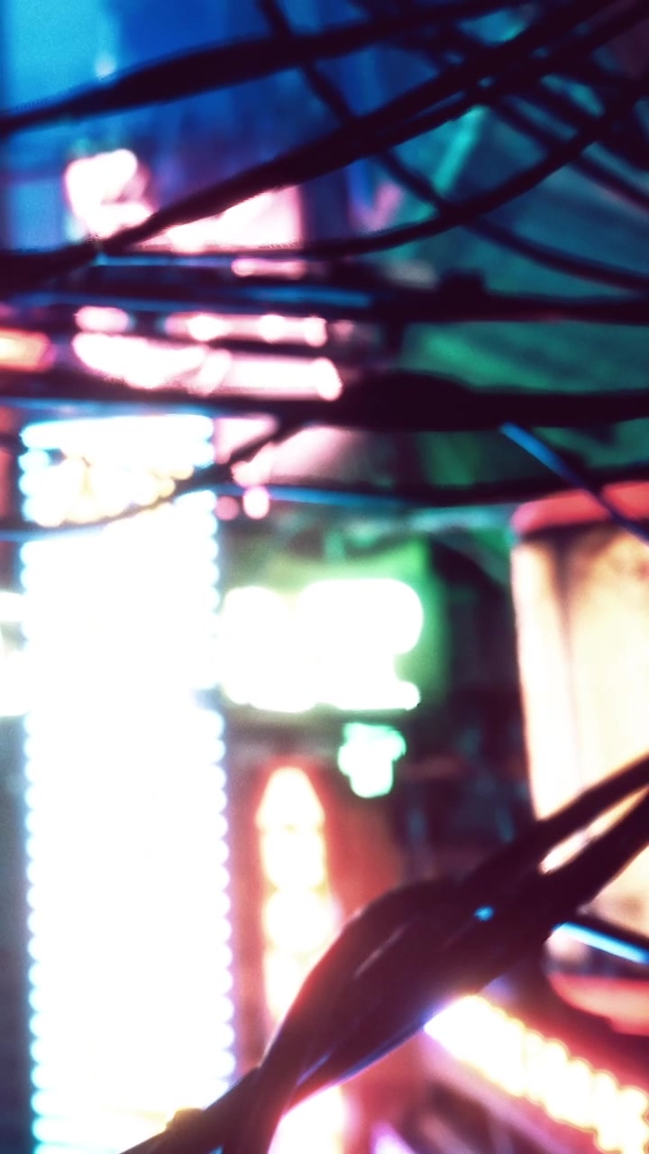 夜の賑やかな都市で、電子ディスプレイの近くに色とりどりの光と配線。