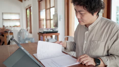 asian man sitting on with laptop and talking to camera