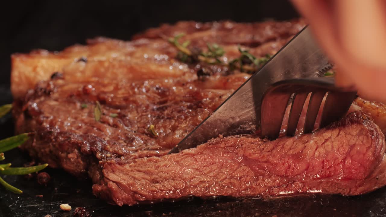 Fresh marbled beef with pepper, salt and rosemary close-up macro. Cutting with knife juicy steak on plate. Premium organic wagyu meat. High quality 4k footage