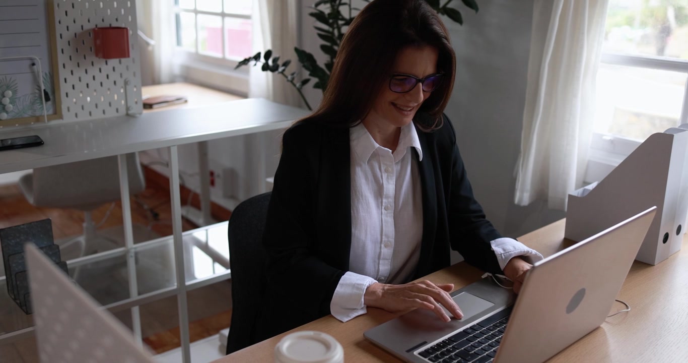 Donna professionista che lavora al laptop in un luminoso home office