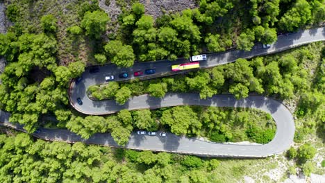 Cars-in-traffic-at-Tracking-drone-shop-of-road-through-green-forested-mountain-range