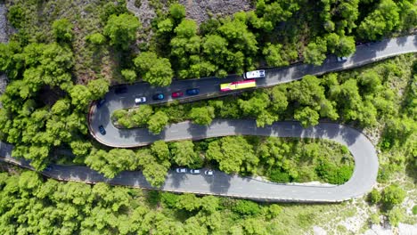 cars in traffic at tracking drone shop of road through green forested mountain range