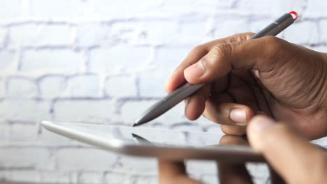 person using a digital stylus on a tablet