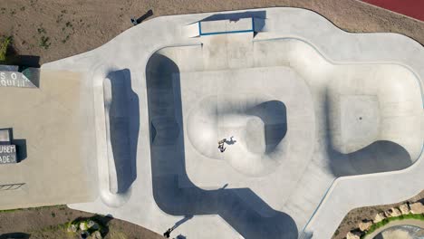 aerial-view-captures-skaters-in-action-at-the-skate-park-in-Parque-das-Gerações,-Lisbon,-Portugal,-showcasing-the-energy-and-skill-of-the-vibrant-skateboarding-community