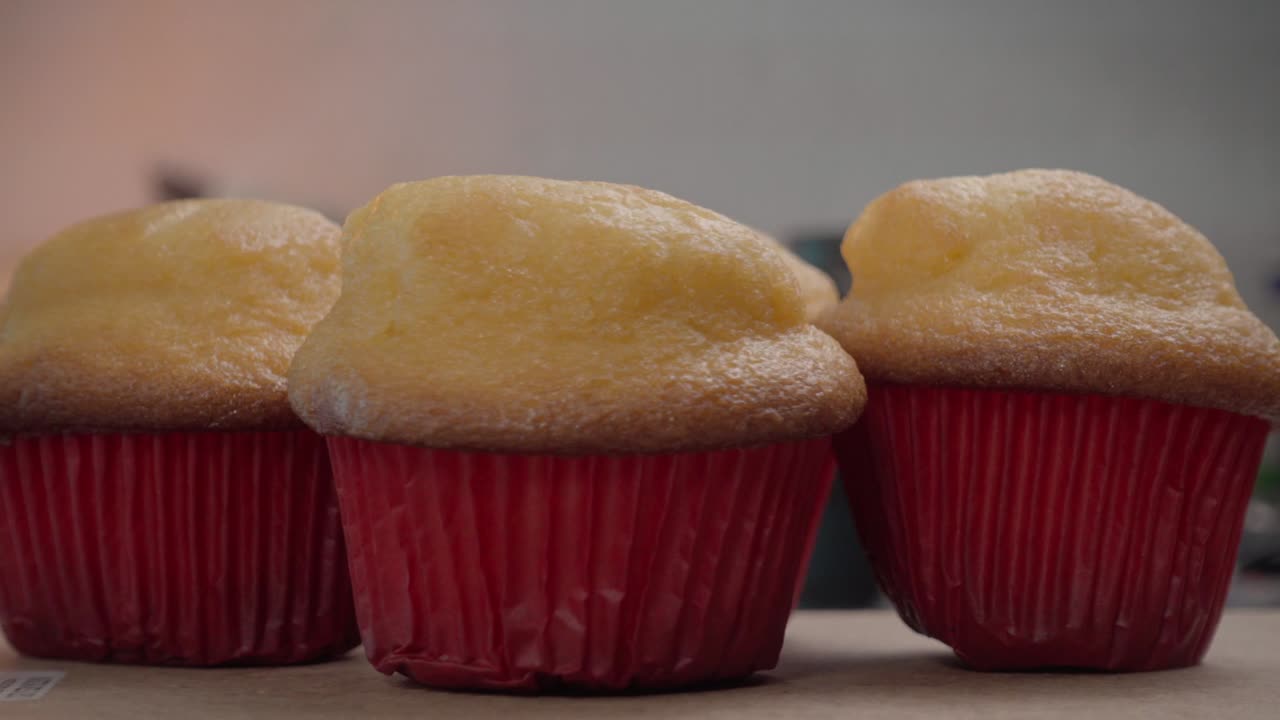 Rotating freshly baked muffins in red liners
