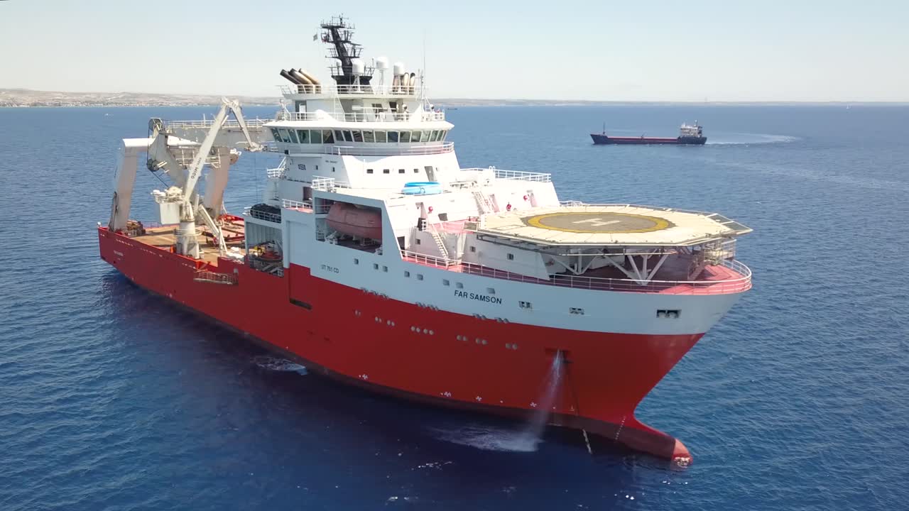 toma en órbita de un enorme barco de instalación de cables anclado en el mar azul de larnaca, chipre