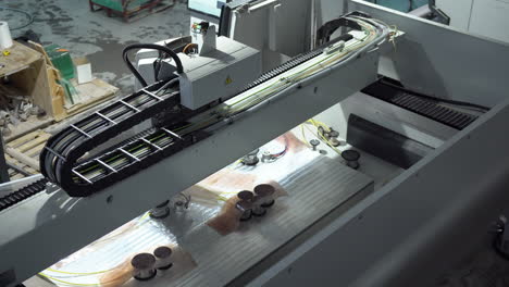 automatic cnc machine working on glass panel in the workshop