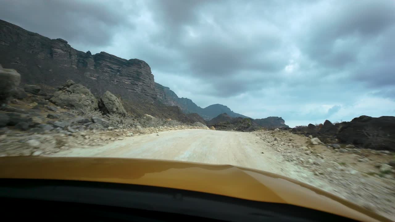 Driving along the rugged Omani terrain near the Yemen border on a moody day - point of view