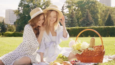 zwei glückliche frauen genießen ein picknick in einem park