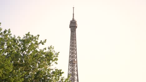 Eiffel Tower top seen in daytime from the Seine river behind Cath&eacute;drale de la Sainte-Trinit&eacute; Russian orthodox church in Paris France, Looking up shot from boat